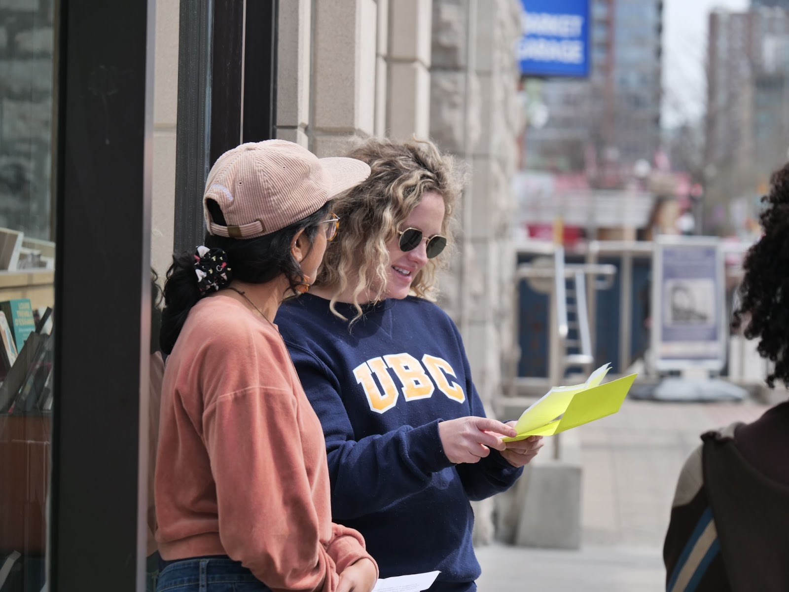 Poet Ambassadors, Manahil Bandukwala and Margo LaPierre, welcome students to their next activity at Librairie du soleil bookstore.