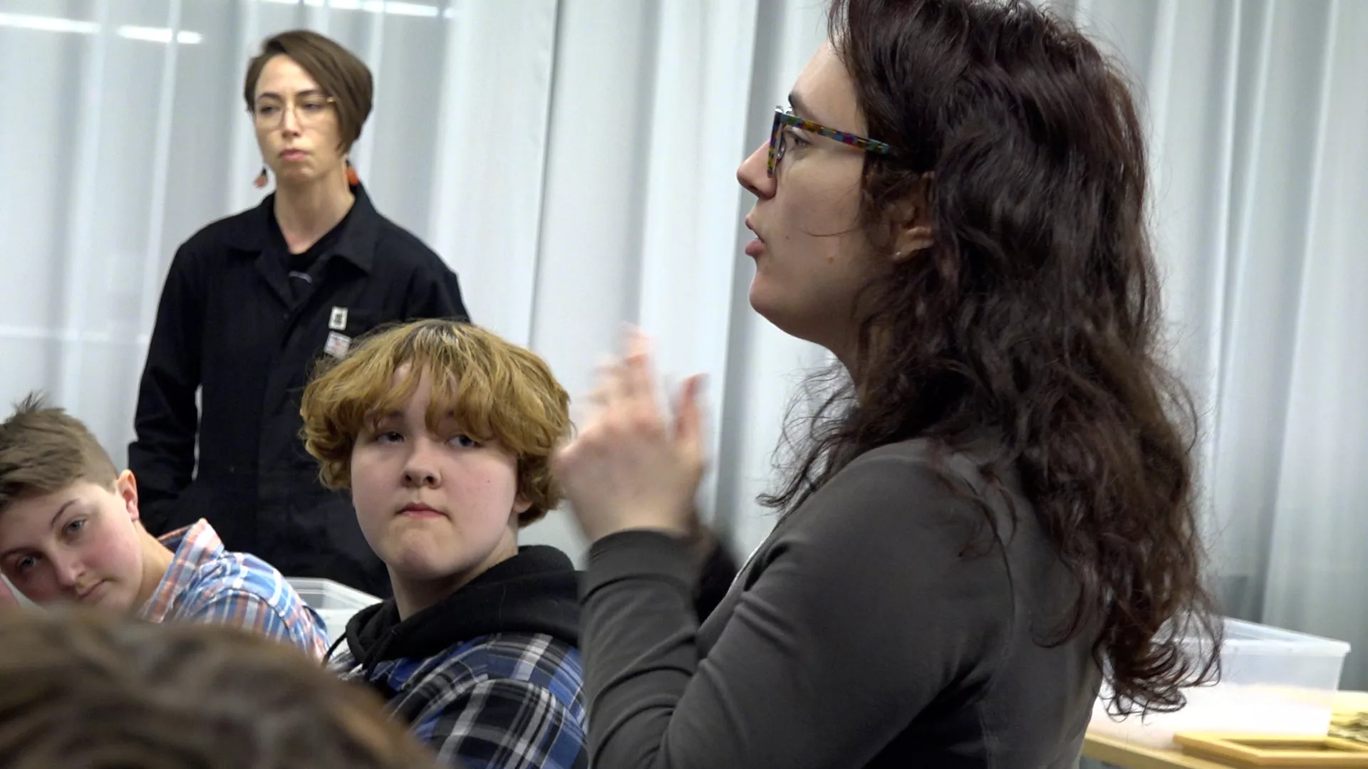 French Program Coordinator Ariane Tapp translates for Kaitlyn Purcell and Tamara Cardinal at the afternoon's cut-up writing workshop and paper making activity.